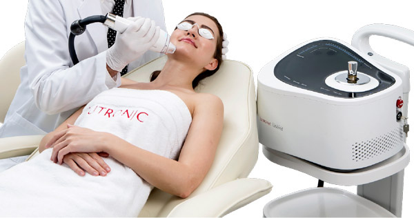 Woman wearing a towel and relaxing in a chair while receiving LaseMD GLO treatment.