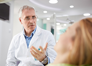Image of a dental professional discussing veneers vs dental crowns, at Dental Care of Burlington in Burlington, MA.