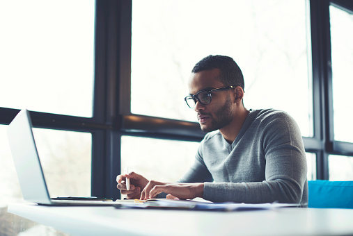 Male patient filling out patient forms on his laptop